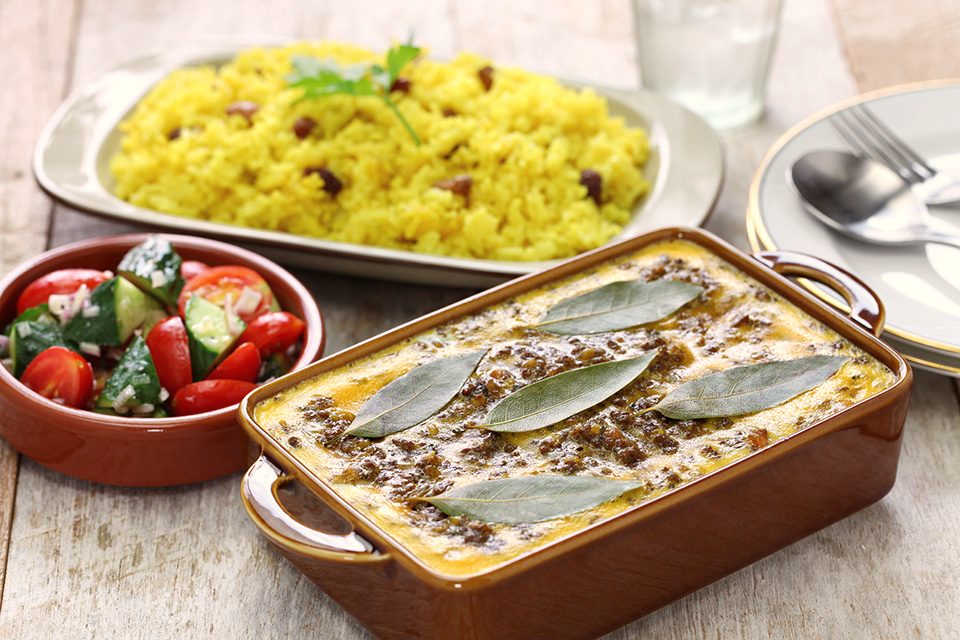 Abundant Cape Malay spread — bobotie, tomato bredie, koesisters and spice bowls