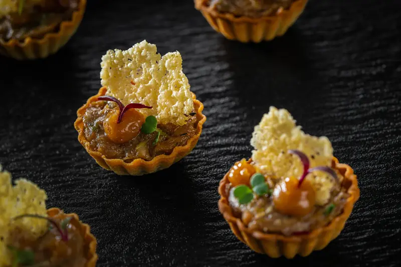 Pastry tartlets with a savoury filling, each crowned with a lacy golden crisp by myCHEF Cape Town
