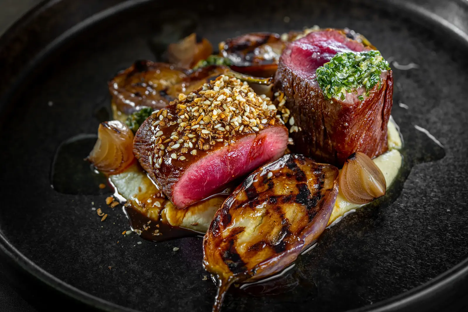 Rare beef with a herb crust, grilled aubergine, roasted shallots and green herb sauce, plated by a private chef in Cape Town for myCHEF Cape Town