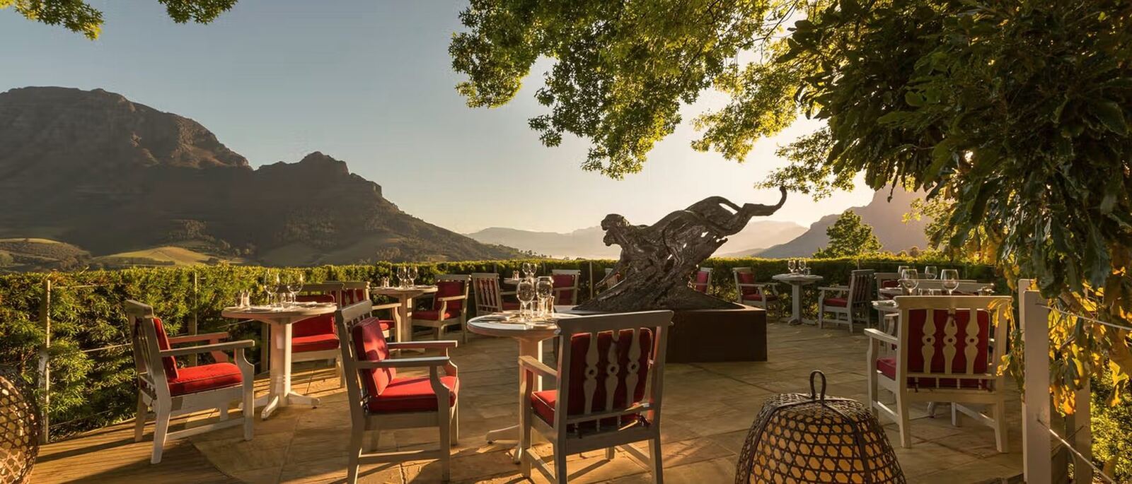 Golden-hour dinner tables on a Cape Winelands estate terrace with mountains behind — myCHEF Cape Town